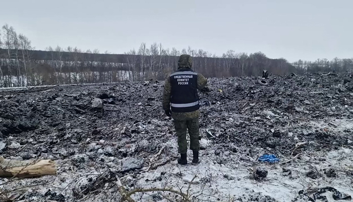 This grab taken from a footage on January 25, 2024 shows an investigator working at the Russian IL-76 military transport plane crash site in the Belgorod region. — AFP