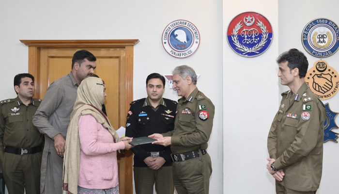 Inspector General Police (IGP) Punjab Dr Usman Anwar (C) gives ownership papers of plots to the family of a martyr of the Sahiwal region on January 27, 2024. — Facebook/Punjab Police Pakistan