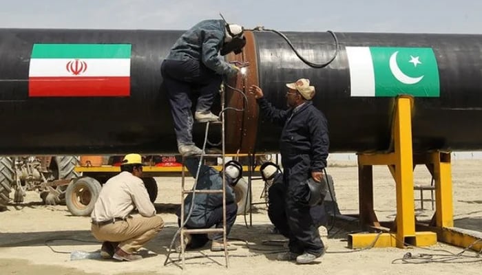 Workers can be seen working on a gas pipeline between Pakistan and Iran. — AFP/File