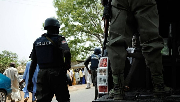 A Nigerian police official stands near a police vehicle. — AFP/File