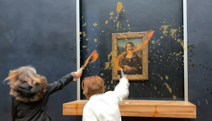 This still taken from AFPTV footage shows two environmental activists from the collective dubbed Riposte Alimentaire (Food Retaliation) hurling soup at Leonardo Da Vincis Mona Lisa (La Joconde) painting, at the Louvre museum in Paris, on January 28, 2024. — AFP