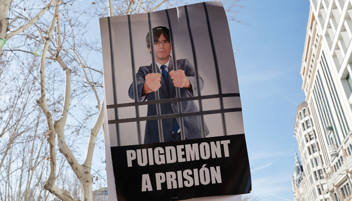 Protestors hold a sign depicting Catalan leader Carles Puigdemont in jail during a demonstration called by the opposition party Partido Popular against the governments amnesty law for people involved in Catalonias failed 2017 independence bid on January 28, 2024. — AFP