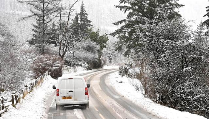 A vehicle can be seen on its way during snowfall. — APP/File