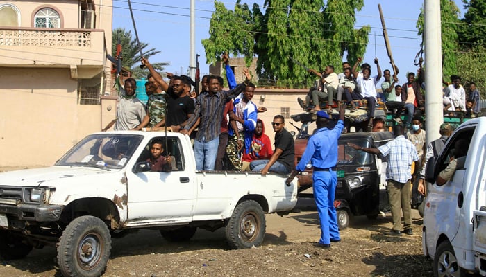Sudanese supporters and members of the Sudanese armed popular resistance, raise their weapons during a meeting with the citys governor in Gedaref, Sudan, on January 16, 2024. — AFP