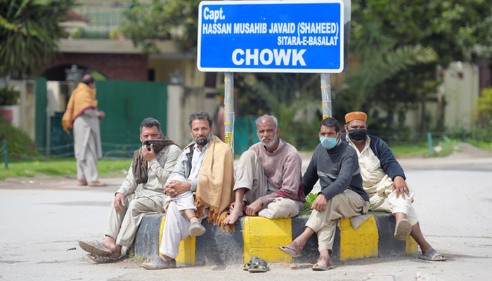 Laborers are sitting on a street in Rawalpindi. — AFP/File