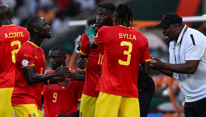 Guineas head coach Kaba Diawara (R) speaks with his players during the cooling break during the Africa Cup of Nations 2024 group C football match between Guinea and Senegal at Stade Charles Konan Banny in Yamoussoukro on January 23, 2024. — AFP