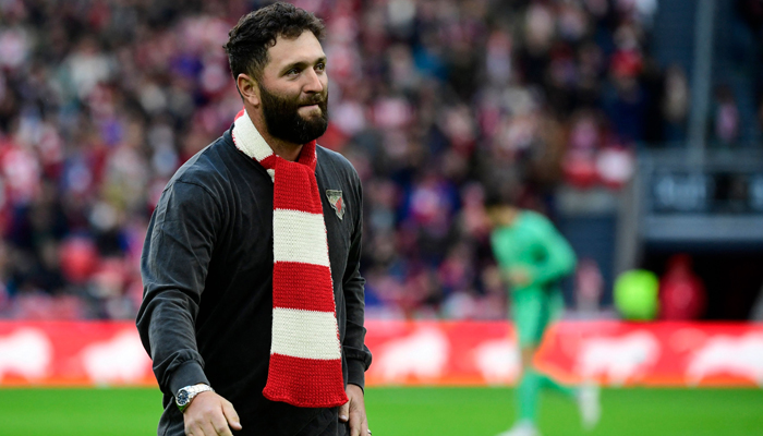Reining Masters champion, Spanish golfer Jon Rahm leaves the pitch after making the honorary kickoff ahead of the Spanish league football match between Athletic Club Bilbao and Club Atletico de Madrid at the San Mames stadium in Bilbao on December 16, 2023. — AFP