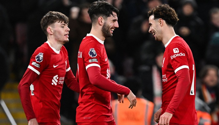Liverpools Dominik Szoboszlai (C) celebrates with Conor Bradley (L) and Curtis Jones (R) after scoring his team third goal during the English Premier League football match between Liverpool and Chelsea at Anfield in Liverpool, north west England on January 31, 2024. — AFP