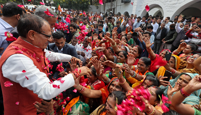 Chief Minister of Madhya Pradesh and member of Bharatiya Janata Party (BJP) Shivraj Singh Chouhan (2L) is greeted by his supporters at his residence in Bhopal on December 3, 2023, following BJP´s victory at the Madhya Pradesh assembly elections. — AFP