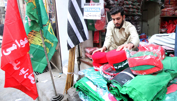 Different parities caps, shirts, badges, and flags are being sold at Mohallah Jangi in Peshawar on January 26, 2024. — PPI