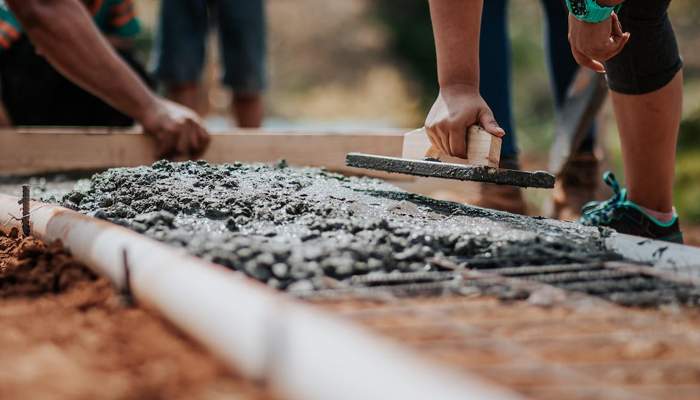 This representational image shows workers filling a concrete cement. — Pexels