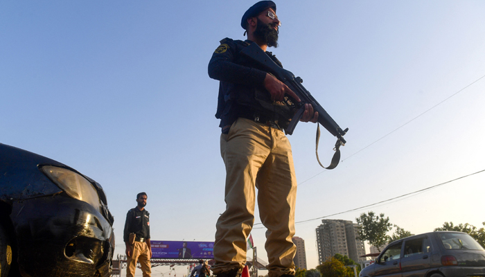 Policemen stand guard along a street in Karachi on February 1, 2024, ahead of the general elections. — AFP
