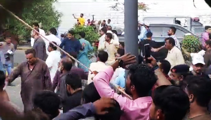 A screengrab of video showing clashes between Jamaat-e-Islami and Pakistan Peoples Party (PPP) workers outside Arts Council situated on the busy MR Kiyani Road in Saddar on June 15, 2023. — YouTube via Geo News