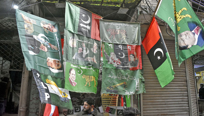 A vendor is displayed political parties flags attraction for customers outside his shop at Ganpat area in Provincial Capital, ahead of the countrys general elections 2024. — Online/File