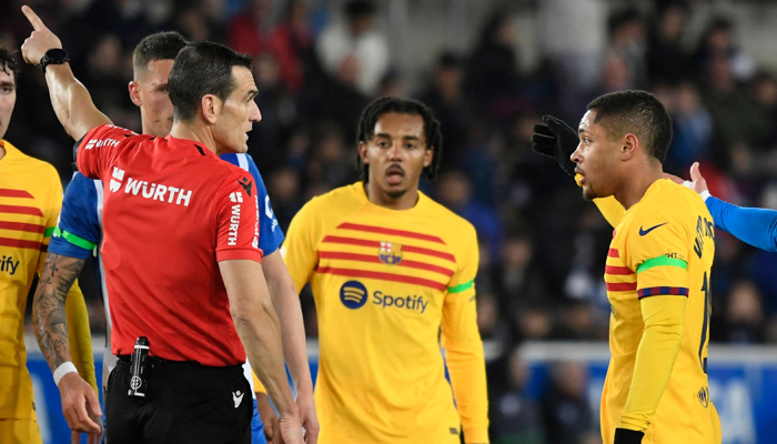 Spanish referee Martinez Munuera sends Barcelonas Brazilian forward  Vitor Roque (R) off the pitch after being presented two yellow cards during the Spanish league football match between Deportivo Alaves and FC Barcelona at the Mendizorroza stadium in Vitoria on February 3, 2024. — AFP