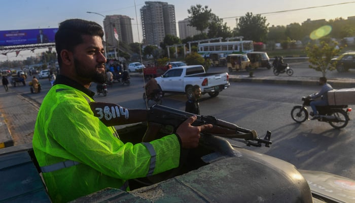 Policemen stand guard along a street in Karachi on February 1, 2024. — AFP