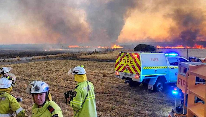 This image shows firefighters watching a bushfire burn north of the city of Perth. — AFP/File
