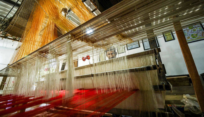 In this image, a worker uses a handloom to weave a traditional Banarasi silk sari at a workshop in Varanasi on November 20, 2021. — AFP