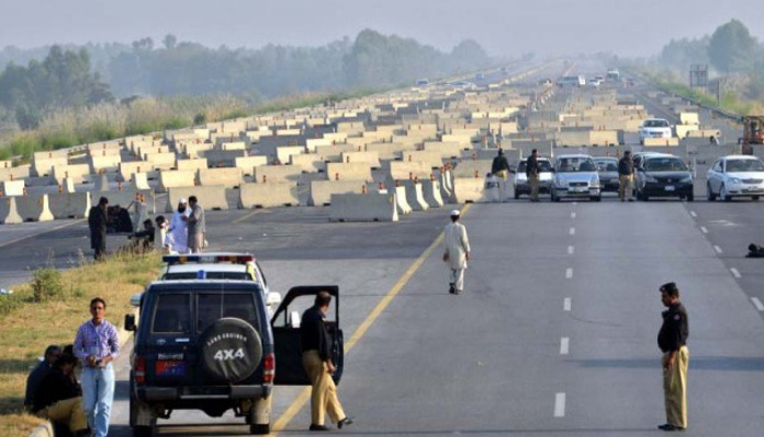 In this image, Police officials stand at a roadblock on the motorway in Swabi. — AFP/File