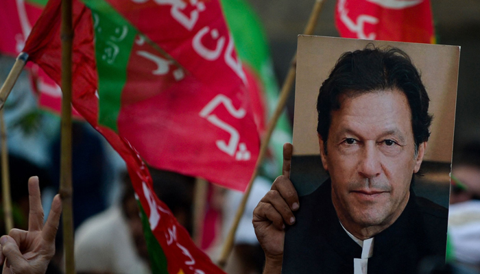 An activist of the opposition party Pakistan Tehreek-e-Insaf (PTI) holds a portrait of Pakistan´s former Prime Minister Imran Khan during an anti-government rally on October 28, 2022. — AFP