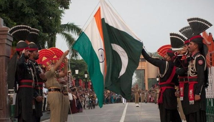 Pakistani and Indian soldiers lower the flags of their countries during a daily ceremony at the Wagah border. — AFP/File