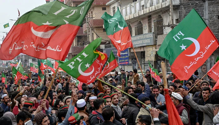 Supporters and activists of the Pakistan Tehreek-e-Insaf (PTI) party hold party flags on the roads of Peshawar on January 28, 2024. — AFP