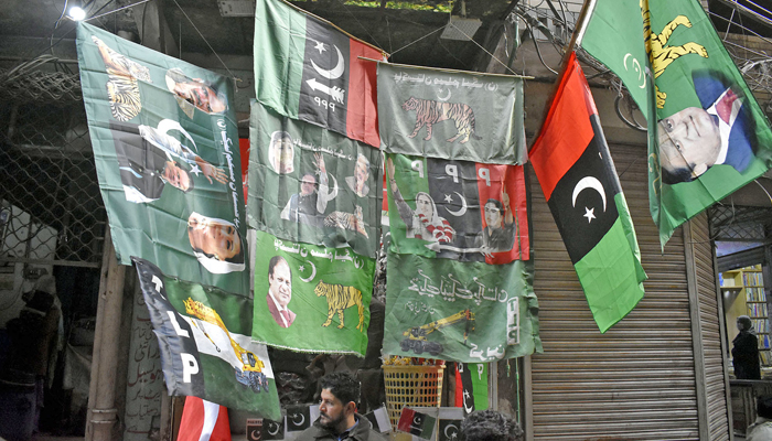 A vendor displaying political party flags attraction for customers outside his shop in the Ganpat area in the Provincial Capital, ahead of the countrys general elections 2024 on January 23, 2024. — Online
