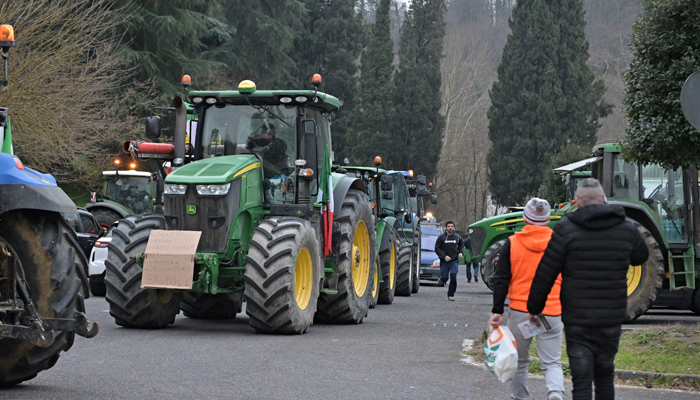 A convoy of tractors is seen in Monterosi, on its way to the outskirts of Rome, as part of an action by farmers to pressure the government to improve their working conditions, near Sutri, on February 5, 2024. — AFP