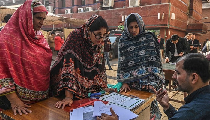 Candidates for the seats reserved for women of Provincial Assembly receive their nomination papers for the upcoming general election at the election commission office in Lahore on December 20, 2023. — AFP