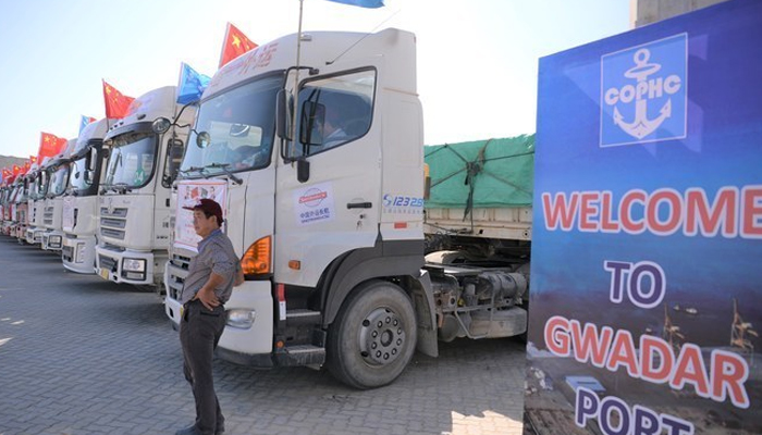 A Chinese worker stands near trucks carrying goods during the opening of a trade project in Gwadar port, some 700 km west of the Pakistani city of Karachi. — AFP/ File