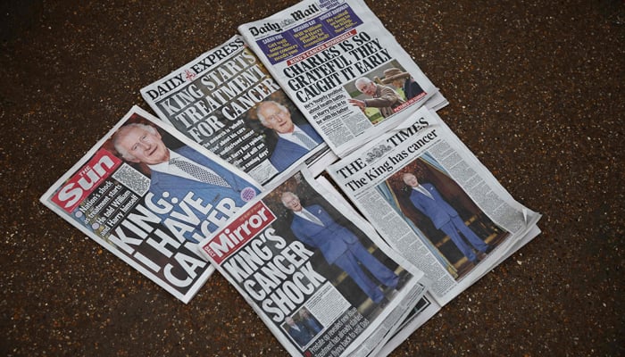 A picture shows the newspaper frontpages about Britain´s King Charles III´s cancer outside Buckingham Palace in London on February 6, 2024. — AFP