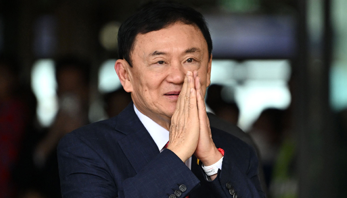 Former Thai Prime Minister Thaksin Shinawatra greets his supporters after landing at Bangkoks Don Mueang airport on August 22, 2023. — AFP