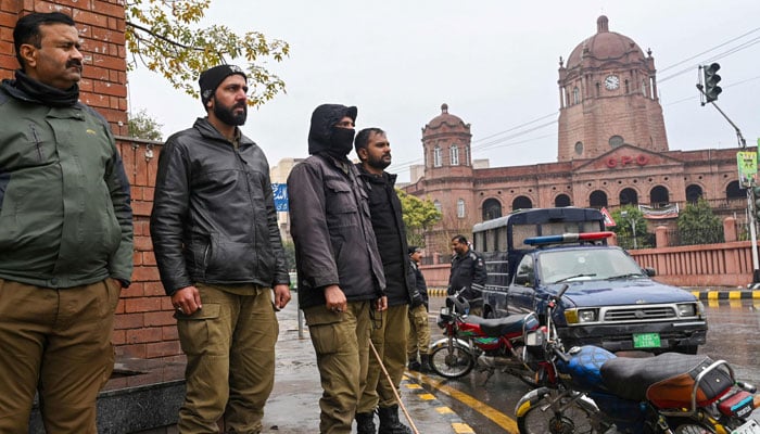 Policemen stand guard along a street ahead of Pakistans national elections 2024, in Lahore on February 4, 2024. — AFP