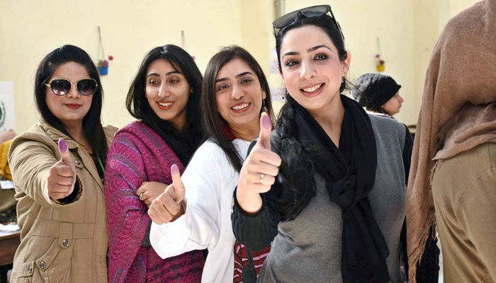 Women voters show their thumb after casting their vote at a polling station during General Election-2024 on February 8, 2024. — APP