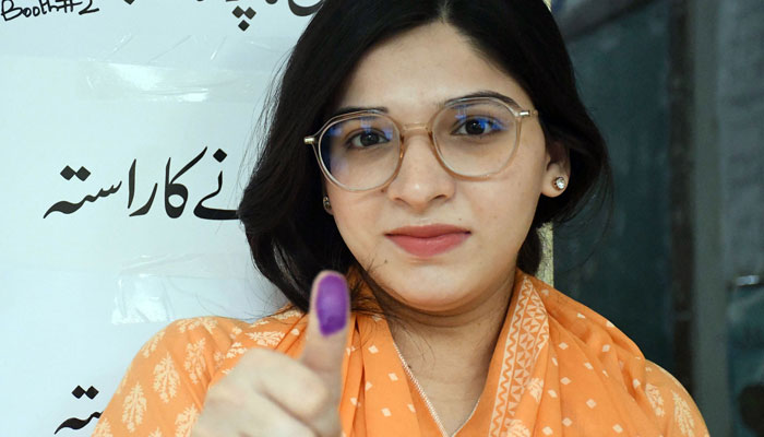 A woman shows her marked thumbs after casting her vote at a polling station during the countrys parliamentary election in Karachi on February 8, 2024. — Online