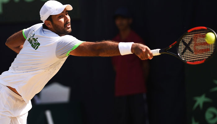 Pakistani Aisam Qureshi returns the ball to Thai opponent Trongcharoenchaikul Wishaya during the Davis Cup Asia-Oceania Group-II Tennis singles final match at the Sports Complex in Islamabad. — AFP/File