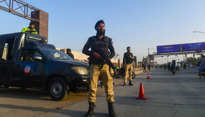 Policemen stand guard along a street in Karachi on February 1, 2024. — AFP