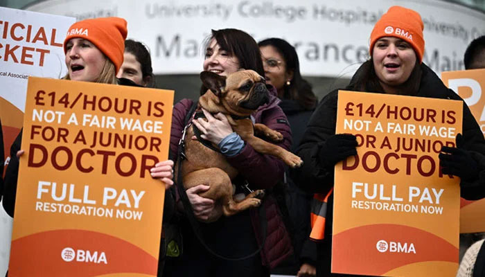 People hold British Medical Association (BMA) branded placards calling for better pay, as they stand on a picket line outside University College Hospital (UCH) in central London, during a strike by junior doctors on April 12, 2023.— AFP