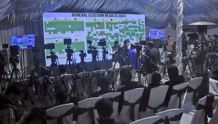 Journalists stand in front of a screen showing the results of countrys parliamentary elections at the Pakistan Election Commission office on February 9, 2024. — Online