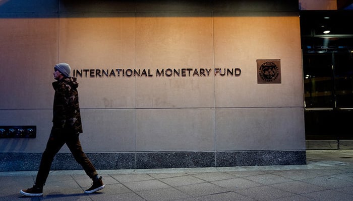 A pedestrian walks past the International Monetary Fund (IMF) headquarters in Washington, DC on January 10, 2022. — AFP