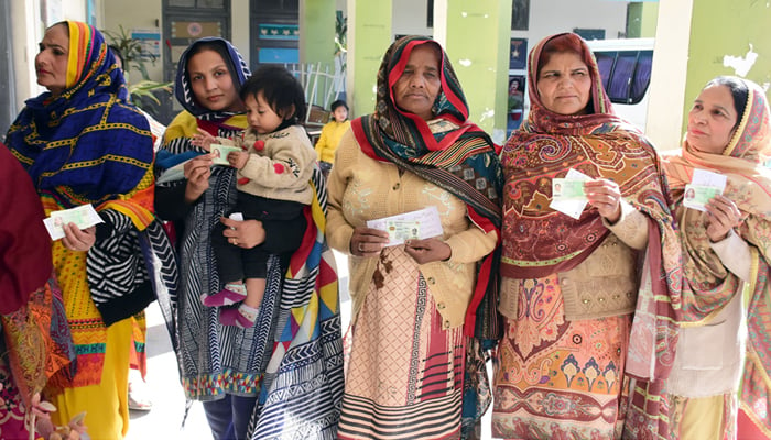 Women hold their national identification cards as they wait their turn to cast votes outside a polling station during the countrys parliamentary elections on February 8, 2024. — Online