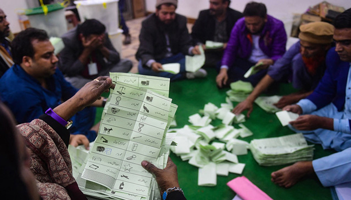 Polling staff start counting votes as polls end during countrys national elections in Karachi on February 8, 2024. — AFP
