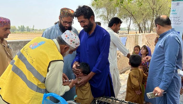 A health worker administrates vaccine drops to a child during Anti-Measles Immunization Campaign, at Malhar Khoso village in Kandhkot on Friday, May 5, 2023. — PPI