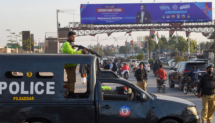 Policemen stand guard along a street in Karachi on February 1, 2024, ahead of the general elections. — AFP