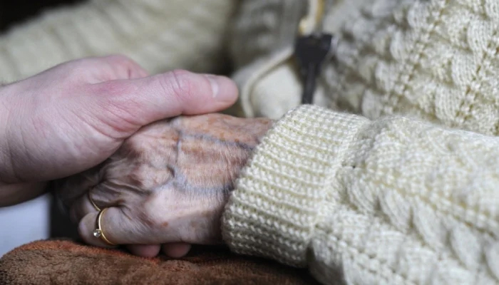 This image shows an old person holding the hands of another. — AFP/Files