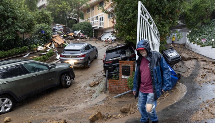 A person walks down as the area is covered with mud and destruction after California storms. — AFP/File