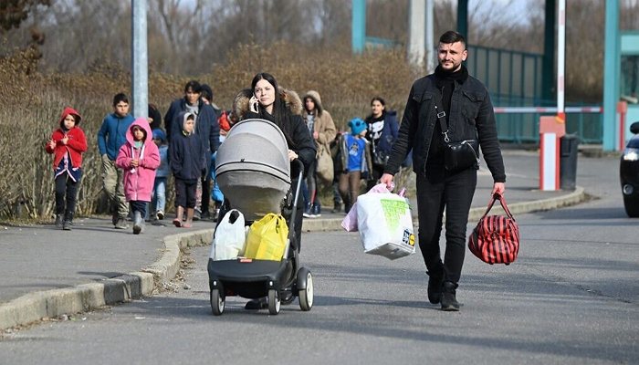 A Ukrainian refugee family and other Ukrainians fleeing their country arrive at the Ukrainian-Hungarian border crossing in Tiszabecs, on February 27, 2022. — AFP
