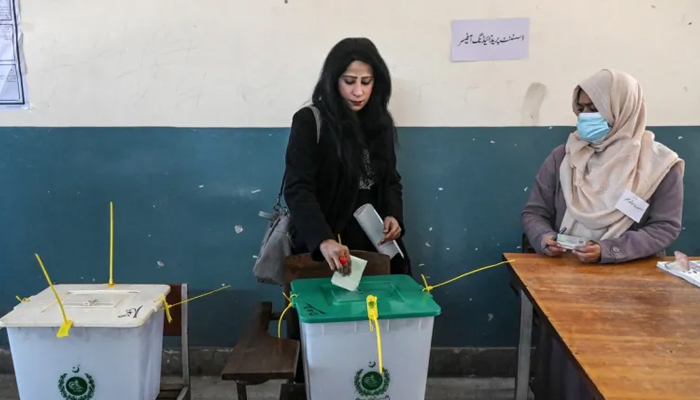 A woman casts her vote at a polling station during Pakistans national election in Lahore on February 8, 2024. — AFP