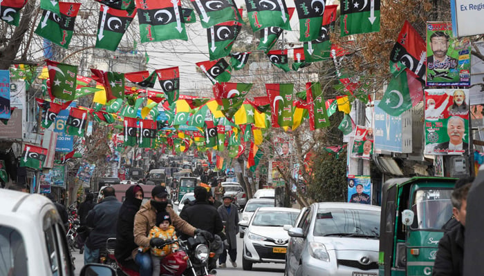 This photo taken on February 3, 2024, shows a street festooned with flags of political parties ahead of Pakistans national elections, in Quetta. — AFP