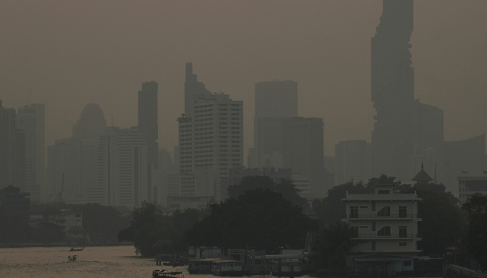 Commuter boats cross the Chao Praya River amid high air pollution levels in Bangkok, Thailand. — AFP